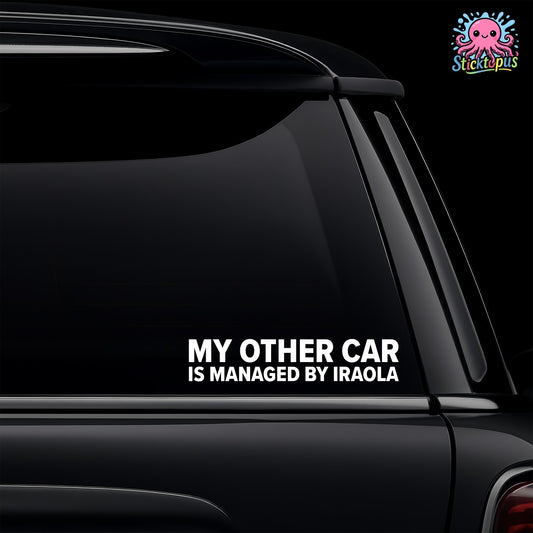 Car window with a decal reading 'My other car is managed by Iraola' on a black background.
