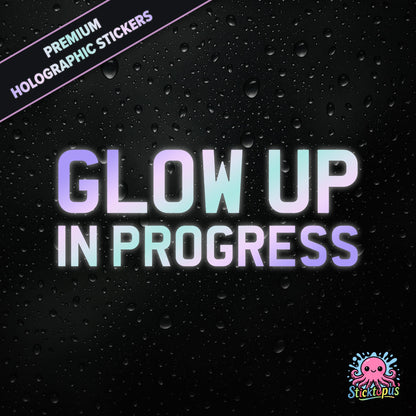 Premium holographic sticker with the phrase “Glow Up in Progress” in bold, pastel-shifting text on a black background with water droplets.