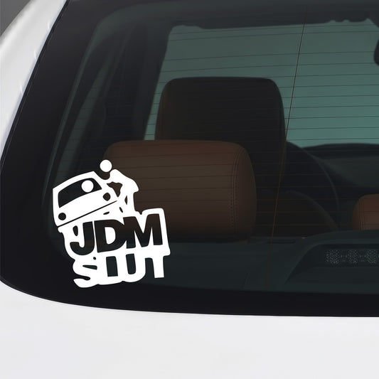 White JDM Slut vinyl sticker applied to a car window.