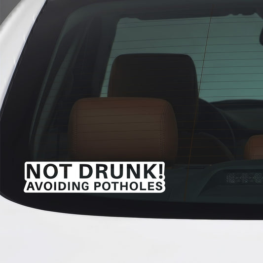 White Not Drunk Avoiding Potholes sticker applied to a car window.