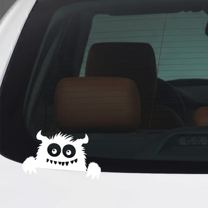 White peeking monster vinyl sticker applied to a car window.