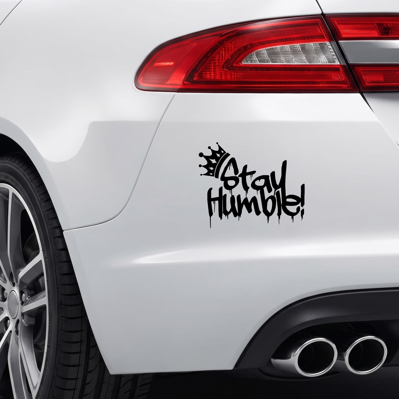 Black Stay Humble graffiti crown vinyl sticker applied to a car bumper.
