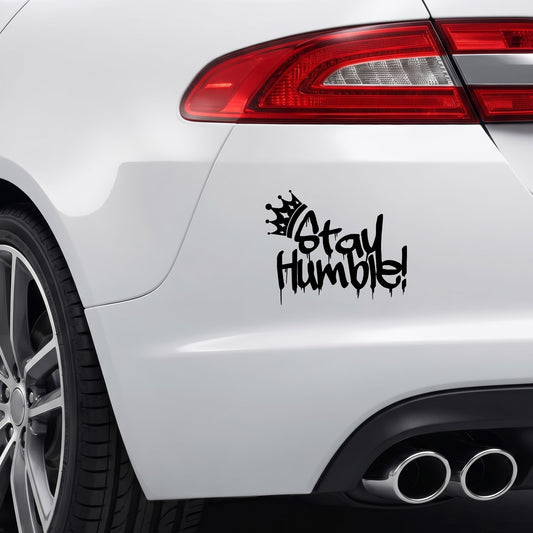 Black Stay Humble graffiti crown vinyl sticker applied to a car bumper.
