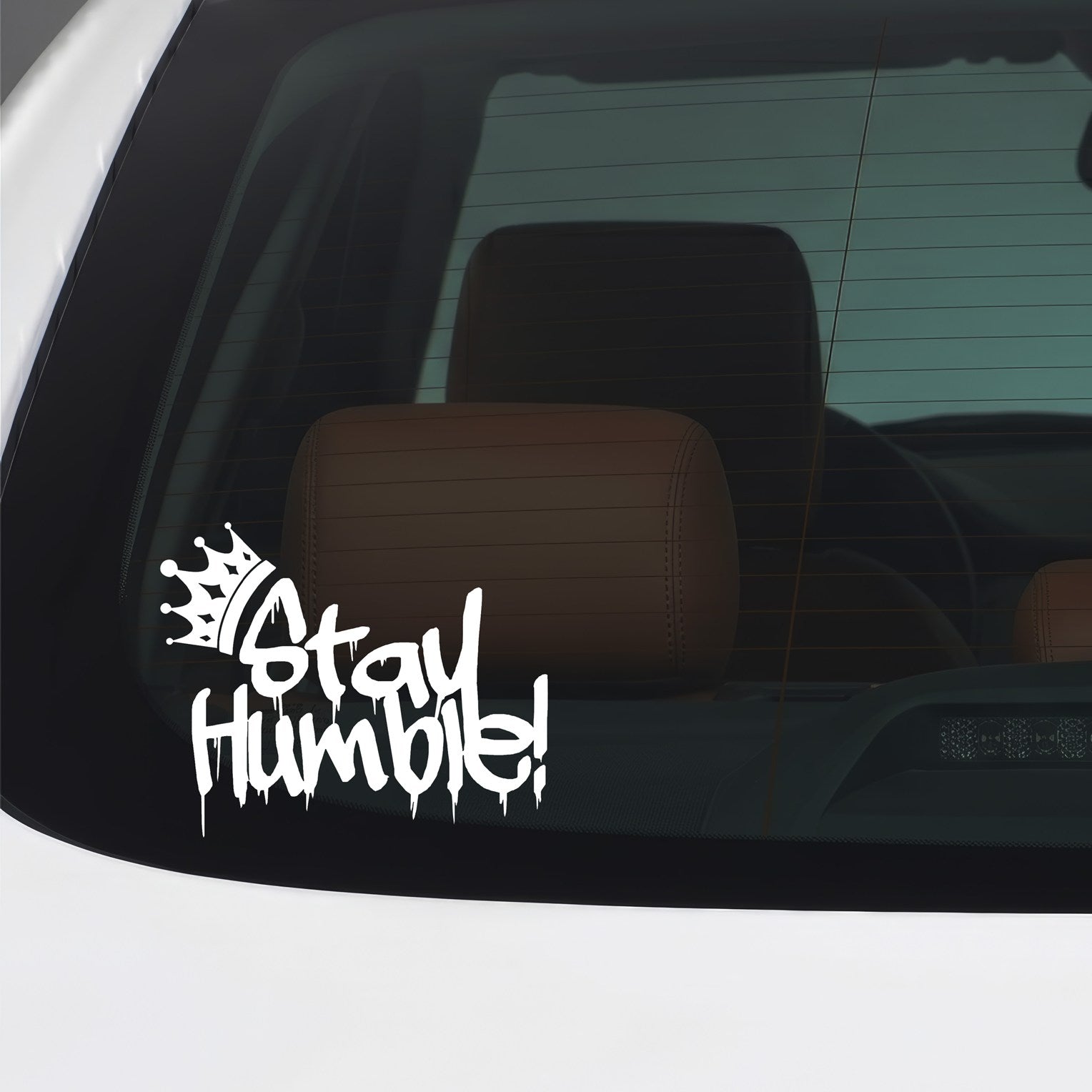 White Stay Humble graffiti crown sticker applied to a car window.