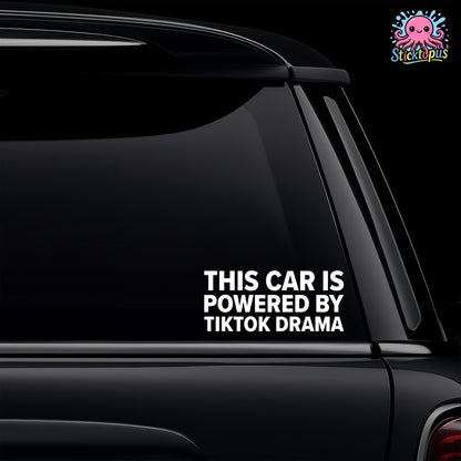 Car window with a decal saying 'This car is powered by TikTok drama' on a black background.