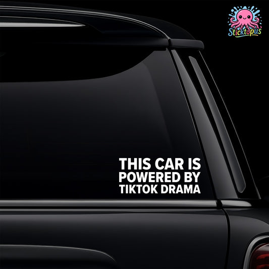 Car window with a decal saying 'This car is powered by TikTok drama' on a black background.
